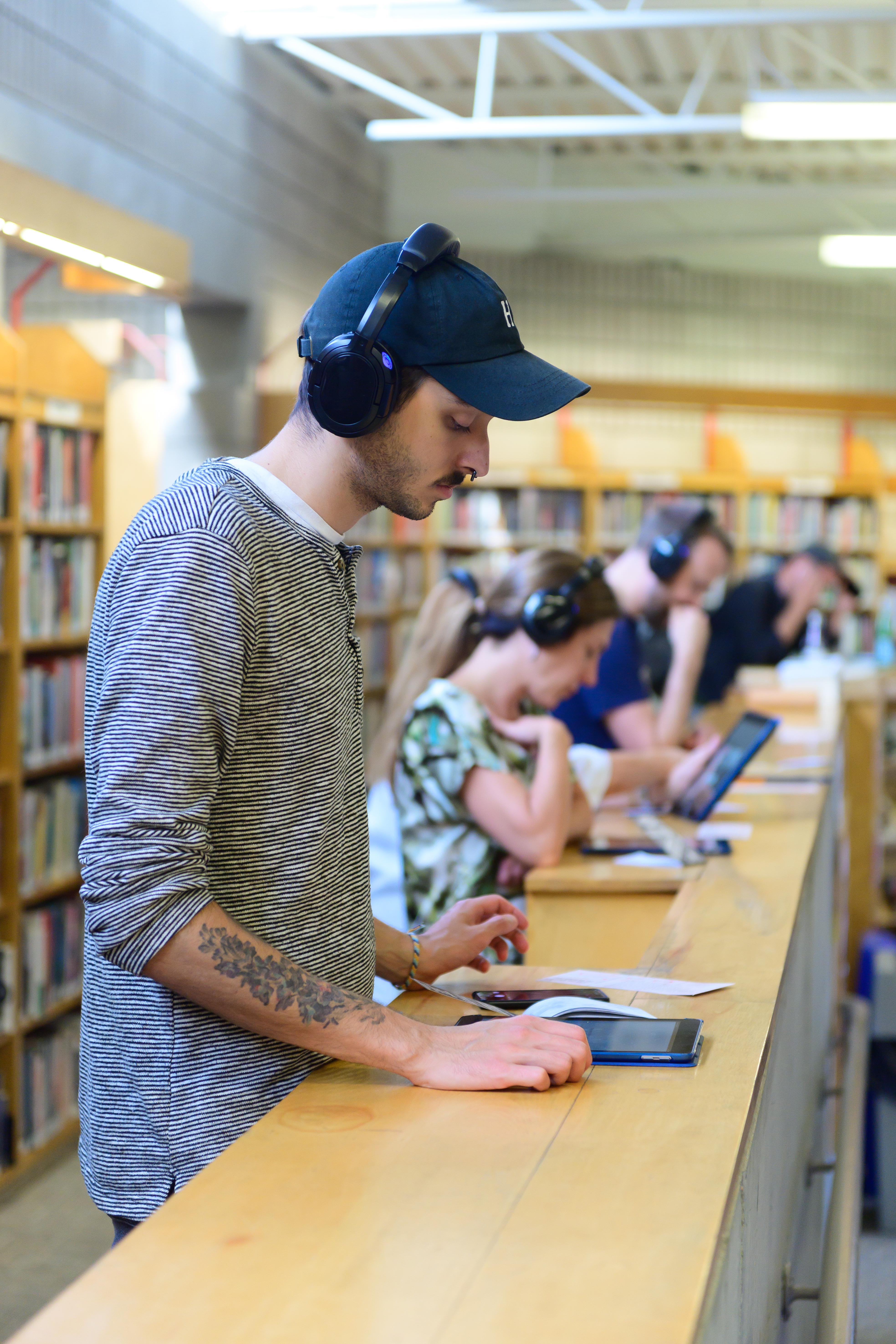 Audience member reads from an iPad in a library.